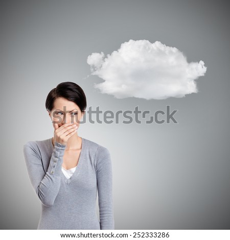 Woman giggles covering her mouth with hand, isolated on grey