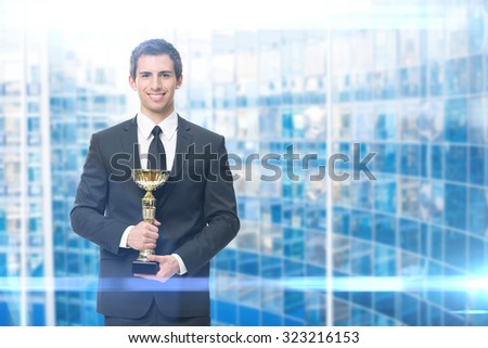 Executive keeping gold cup, blue background. Concept of victory and success