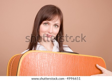 Young traveler with suitcase isolated on beige background