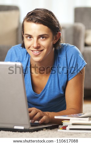 young man is doing his homework on a laptop