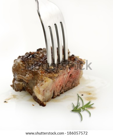 Piece Of medium-rare steak On A Fork, Close Up