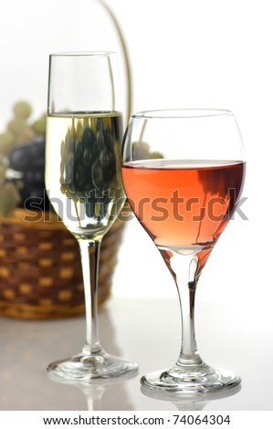 white and pink wine glasses and basket with grape