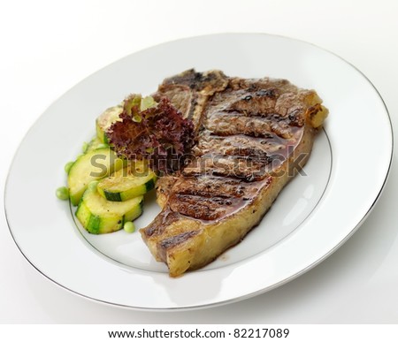 grilled t-bone steak and vegetables , close up
