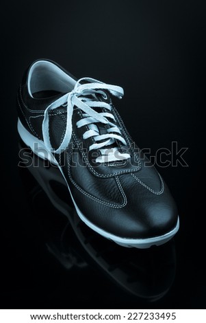 black leather man's shoe on black background