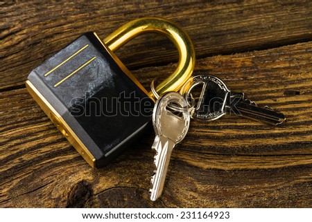 hinged lock with keys on wooden background