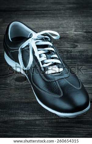black leather man\'s shoe on wooden background