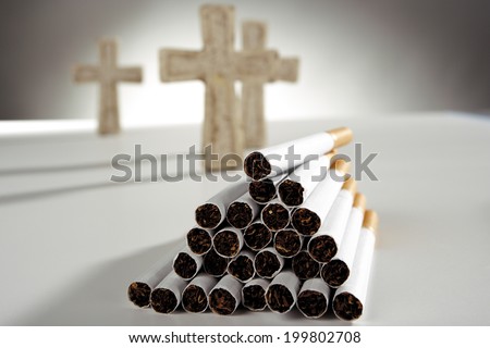 Pile of cigarettes, three crosses in background