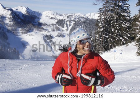 Young woman in snow holding ski sticks
