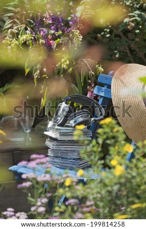 Austria, Salzburger Land, Stack of CDs with head phone on chair in garden