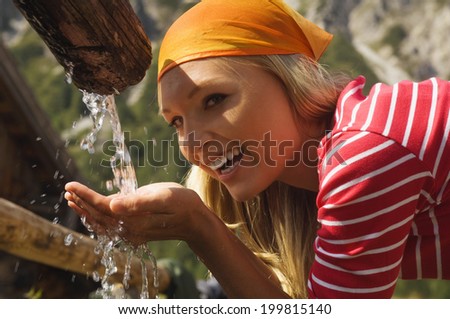 Blonde woman drinking water, portrait