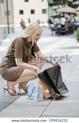 Young woman seeking something in her shopping bags