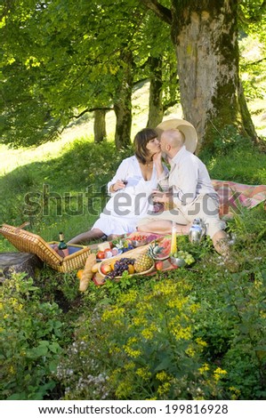 Couple having picnic under tree