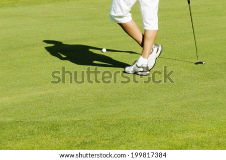 Man standing on putting green, low section