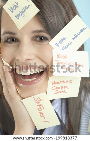 Businesswoman with adhesive notes, smiling
