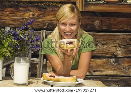 Austria, Salzburger Land, blonde woman drinking milk, eating pastries