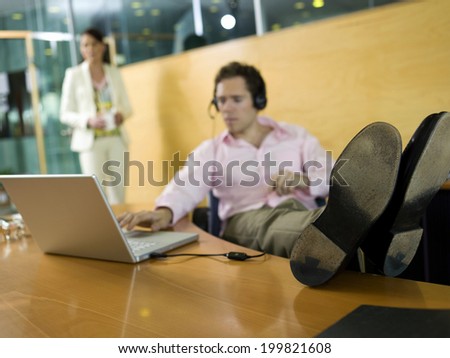 Young man in office, feet on desk