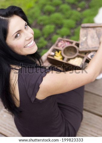 Woman holding incense box, smiling, elevated view