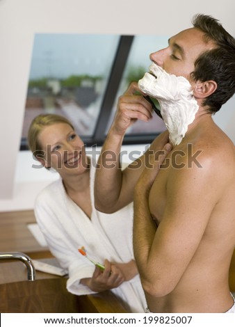 Couple in bath, man shaving