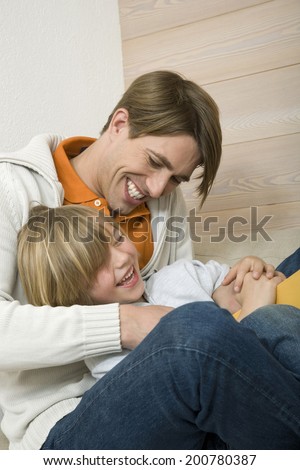 Father and son playing father tickling son laughing
