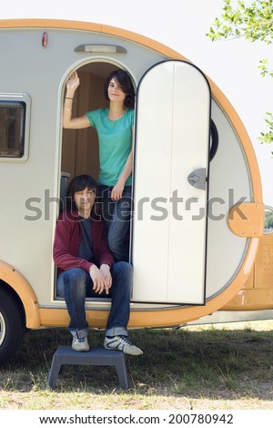 Young couple in camping trailer