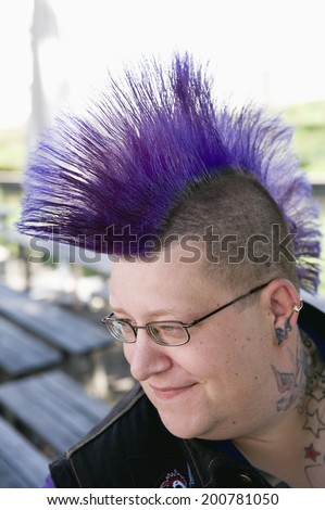 Germany, Bavaria, Upper Bavaria, punk with purple mohawk haircut wearing glasses tattoos on neck