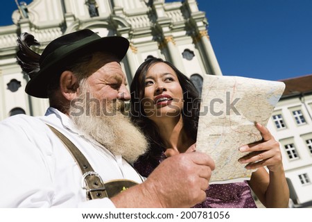 Germany, Bavaria, Upper Bavaria, asian woman and old Bavarian man looking at map