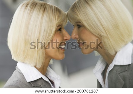 Blonde businesswoman smiling looking at mirror reflection