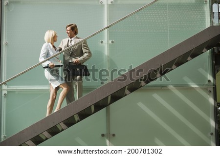 Business people standing on stairs having conversation