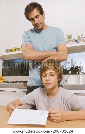 Father and son boy with report card man watching