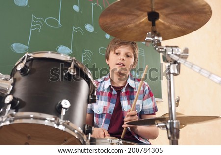 Boy playing drums at music class