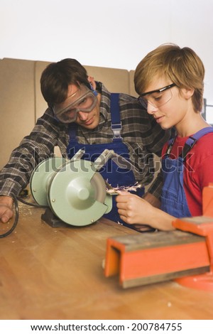 Father and son working on grinding machine