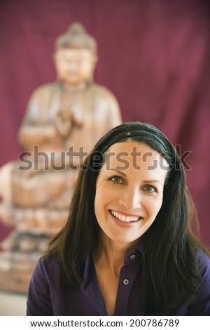 Portrait of a woman buddha statue in background