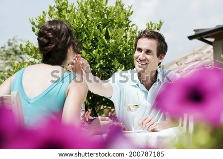 Italy South Tyrol couple in restaurant man feeding woman with tomato
