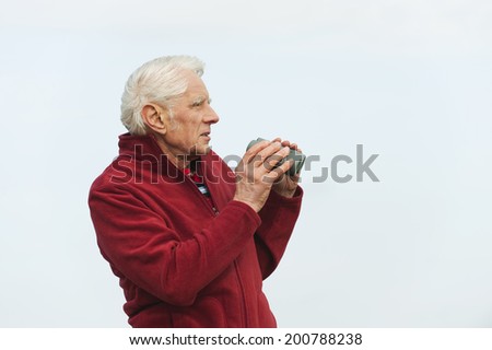 Germany, St.Peter-Ording, North Sea, Senior man holding binoculars