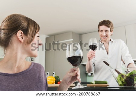 Germany, Hamburg, Man and woman with wine glass in kitchen