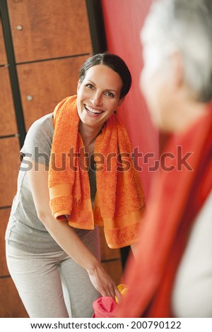 Two women in changing room towel round shoulders smiling