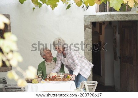 Couple with fruit snacks and wine on table