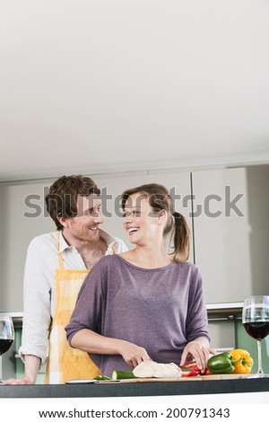 Germany, Hamburg, Man and woman in kitchen preparing salad