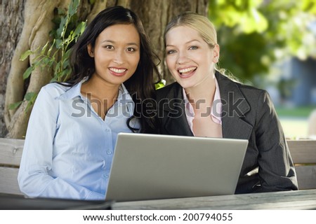 Germany, Bavaria, Upper Bavaria, two Businesswomen in beer garden using laptop