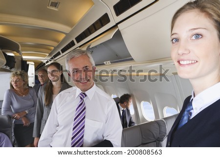 Businessman smiling at air hostess on airplane