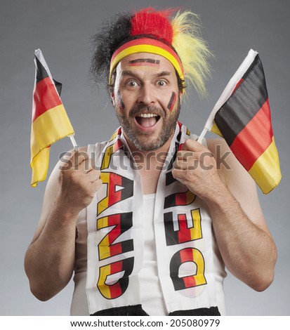 Ecstatic german soccer fan holding german flags in both hands