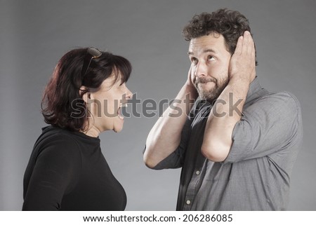 Mature couple quarreling woman shouting man covering ears