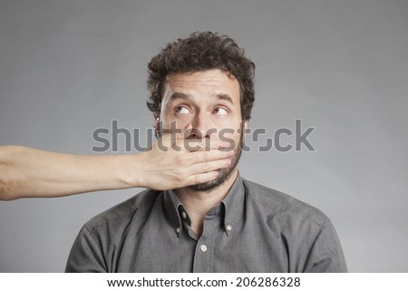 Woman\'s hand covering mature man\'s mouth