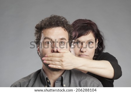 Mature couple woman covering man\'s mouth