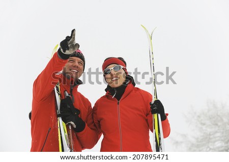 Italy, South Tyrol, Couple in ski wear, man pointing