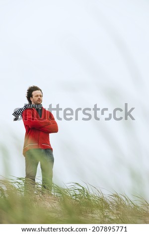 Germany St Peter-Ording North sea man standing on sand dune with arms crossed