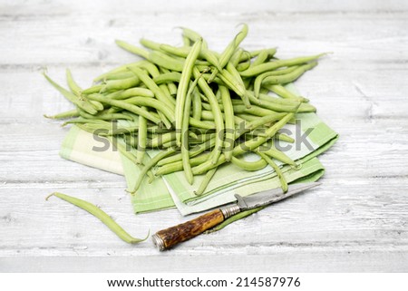 Raw green beans antique knife on cloth napkin