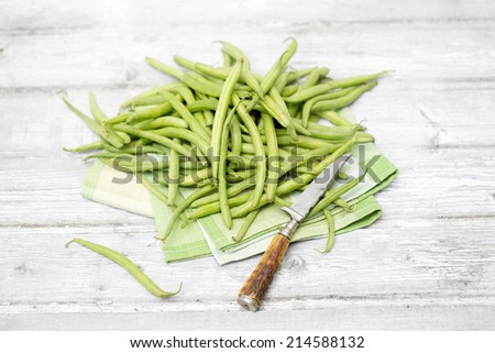 Raw green beans antique knife on cloth napkin