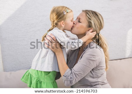 Mother and daughter kissing each other