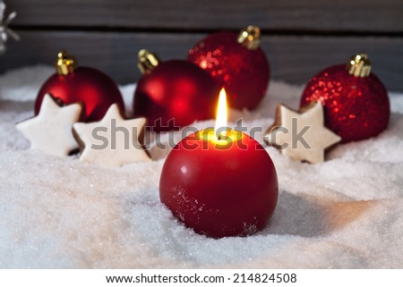 Christmas bulbs cinnnamon stars candle on pile of snow